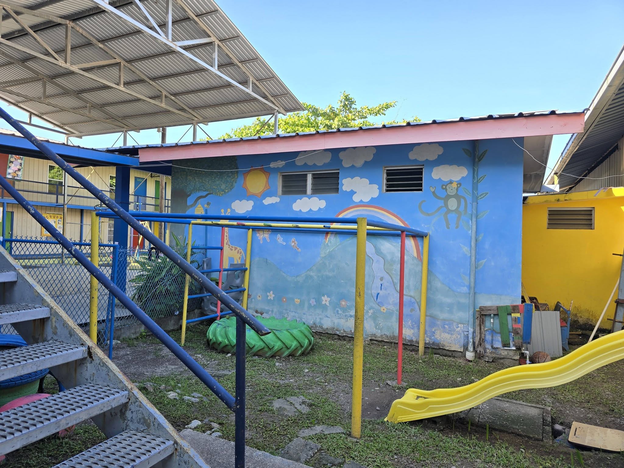 Área de juegos del colegio con resbaladero y estructura para trepar